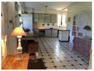 a kitchen with a table and a lamp on a floor at Domaine et Château de Séréville in La Belliole +27 photos
