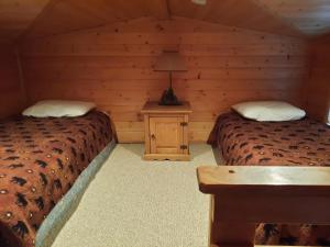 a room with two beds and a table in a cabin at Willamette Pass Inn & Chalets in Odell Lake
