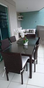 a dining room table and chairs with a glass table at Apartamento condomínio Ilha Bela - Braga in Cabo Frio +16 photos