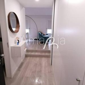 um corredor com um espelho e uma cadeira num quarto em AmaRiaCity AL em Aveiro