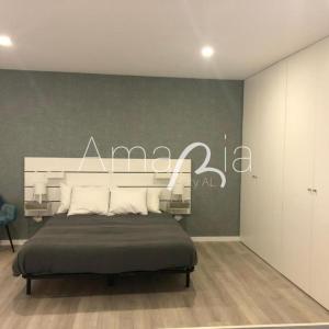 a bedroom with a bed with a sign on the wall at AmaRiaCity AL in Aveiro