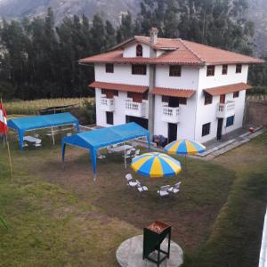 un bâtiment avec des tables et des parasols devant lui dans l'établissement Lodge Acopampa Inn, à Carhuaz