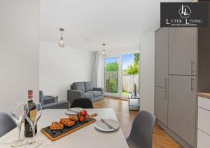 una cucina e un soggiorno con tavolo e piatto di cibo di Lyter Living Serviced Accommodation Oxford-Hawthorn-with parking a Oxford