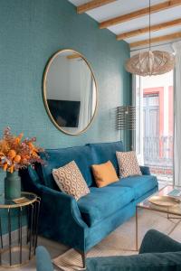 a blue couch in a living room with a mirror at Hernando Colón Olehousing in Seville