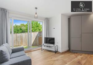 a living room with a couch and a television at Lyter Living Serviced Accommodation Oxford-Hawthorn-with parking in Oxford