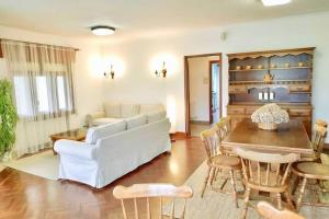 a living room with a white couch and a table at Covas Beach Garden in Viveiro