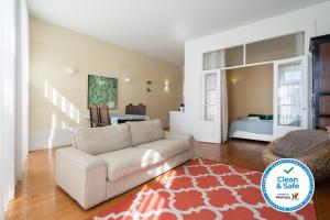 a living room with a white couch and a red rug at Homely Noble Flats - Garden & Jacuzzi in Porto