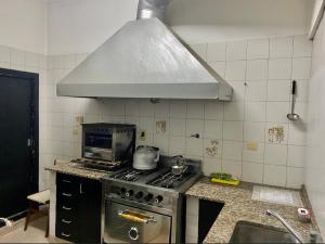 a kitchen with a stove with a pot on it at Hostel Playa Grande Güemes in Mar del Plata