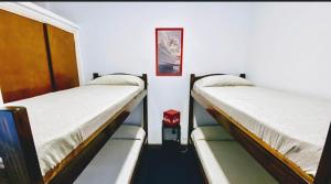 En eller flere senge i et værelse på Hostel Playa Grande Güemes