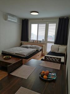 um quarto com duas camas e uma tigela de fruta numa mesa em Slaný - byt 1+1 em Slany