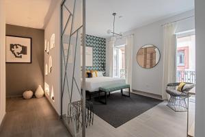 a bedroom with a bed and a mirror at Hernando Colón Olehousing in Seville
