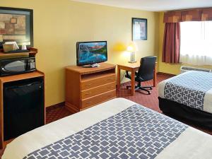 una camera d'albergo con due letti e una televisione di HUTCHI BELL a South Hutchinson