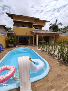 uma piscina em frente a uma casa com em Pousada Marcos no Guarujá