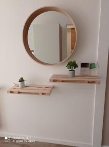 a mirror on a wall next to a table with plants at PIVOINE -12 Min des parcs Walt Disney-Arrivée autonome-Wifi&Parking gratuit in Montévrain