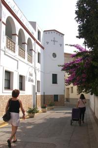 two women walking down a street in front of a building at Hostal La Florida in Llança