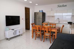 uma cozinha com uma mesa e cadeiras e um frigorífico em SleepWell Suite em Majdal Shams