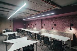 a row of tables and chairs in a room with a brick wall at UMA Suites Chia in Chía