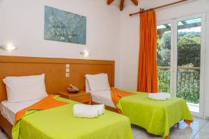a bedroom with two beds and a window at VILLA MITZELOS in Skiathos