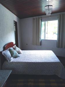 Una cama o camas en una habitación de Suíte Mar Doce Lar