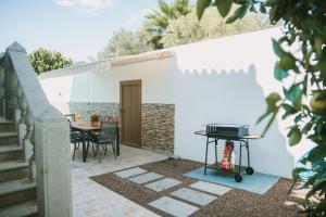 a patio with a table and a grill at Villa Cervantes Sonnenland con piscina privada climatizada in Maspalomas