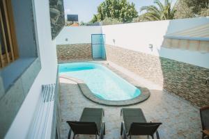 una piscina sul lato di un edificio di Villa Cervantes Sonnenland con piscina privada climatizada a Maspalomas