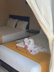 a hotel room with two beds with towels on them at HOTEL MARIPOSA in Zihuatanejo