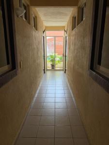 a hallway with a tile floor with a plant in it at HOTEL MARIPOSA in Zihuatanejo