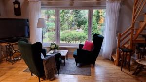 a living room with chairs and a large window at Fort Janowek in Janówek