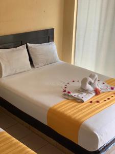 Una cama con dos toallas encima. en HOTEL MARIPOSA en Zihuatanejo