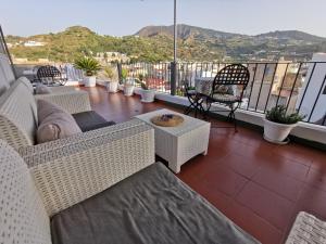 balcón con muebles de mimbre y vistas a las montañas en Lo Nardo Accommodation, en Lipari