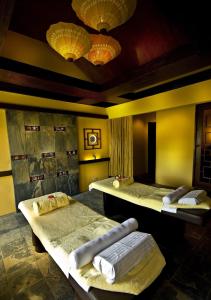 two beds in a room with yellow walls and lights at Henann Regency Resort and Spa in Boracay