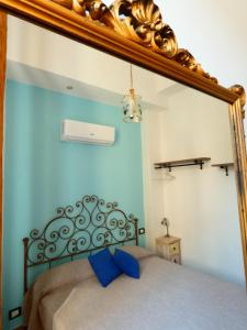 a mirror above a bed in a room at Casa Matuzia in Sanremo