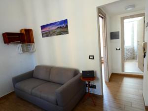a living room with a couch and a laptop on a table at Casa Matuzia in Sanremo