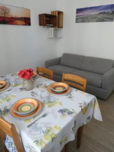 una mesa de comedor con platos y flores. en Casa Matuzia en San Remo