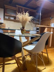 a dining room with a glass table and white chairs at Girske Povitria Cottage in Yaremche +144 photos
