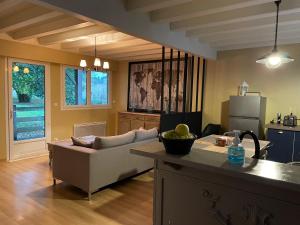 eine Küche und ein Wohnzimmer mit einem Sofa und einem Tisch in der Unterkunft Le Maine N 5 FLEAC - Logement entier avec 3 suites SDB - Balcon in Fléac