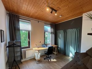 Zimmer mit einem Schreibtisch und 2 Fenstern in der Unterkunft Bettchen - Helle charmante Wohnung mit Hochebene in Bremerhaven