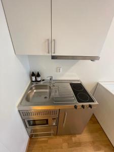 eine Küche mit Spüle und Herd in der Unterkunft Clean and Modern - 25 Min to Oslo City & OSL in Lillestrøm