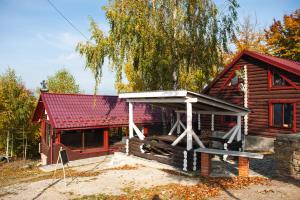 eine kleine Blockhütte mit rotem Dach in der Unterkunft Hygge House in Vyshka