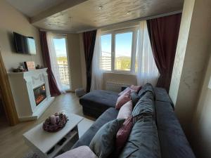 ズラティボールにあるLux Apartman Gondola 94 -KLIMATIZOVANのソファと暖炉のあるリビングルーム