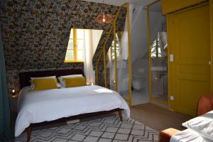 Un dormitorio con una cama con almohadas amarillas. en La maison des champs , Chambres d'hotes , receptions, en Novillers-les-Cailloux