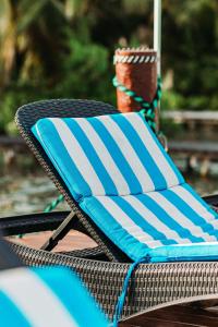 a wicker chair with a blue and white towel at Blue Bird in Bacalar