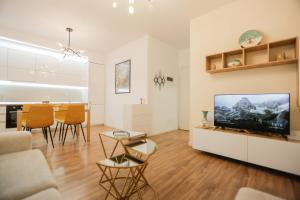 a living room with a television and a table at Miku Apartment-Sophisticated 2BD Apartment At Taiwan in Tirana