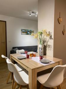 uma mesa de jantar com cadeiras brancas à volta em Gite "Le Platane" 45 m2 - climatisé em Monswiller