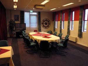 a conference room with a long table and chairs at Hotel Orion in Kaag
