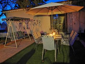 a table and chairs under an umbrella in a yard at Soutpan Guesthouse in Soutpan