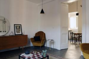 ein Wohnzimmer mit einem Stuhl und einem Tisch in der Unterkunft Minimal chic-Teatro Massimo Bellini in Catania