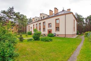 an old house with a green yard in front of it at Ratibora Jurata, Sun & Snow in Jurata