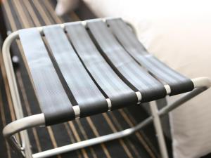 a black and white chair sitting next to a bench at APA Hotel Keikyukamata Ekimae in Tokyo