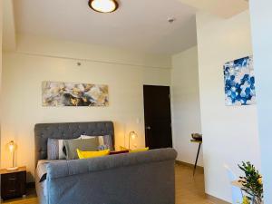 a living room with a bed and a couch at 2 BR Corner Executive Suite at Lafayette Park Square Megaworld Blvd Unit 5H in Iloilo City +21 photos